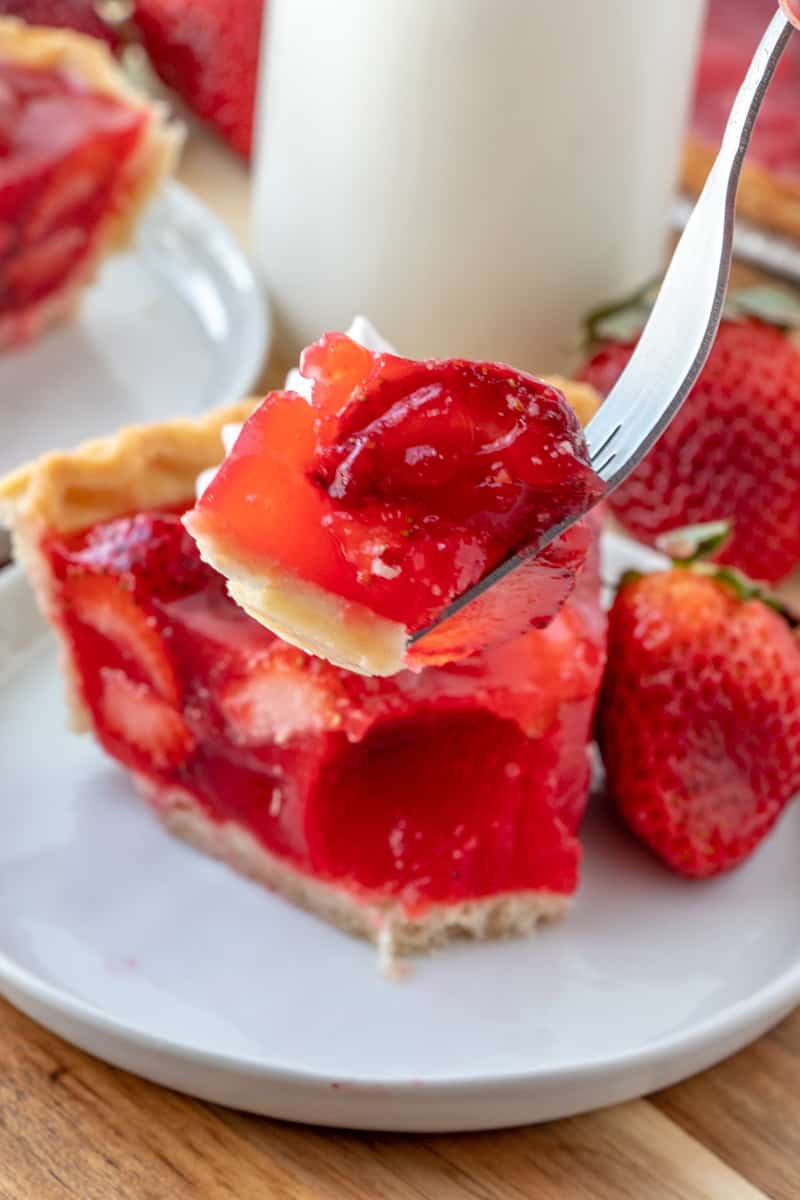 Easy delicious and bursting with flavor this Strawberry Pie is an old-fashioned recipe that has minimal ingredients intense strawberry flavor and absolutely addicting. Slice of strawberry pie on fork